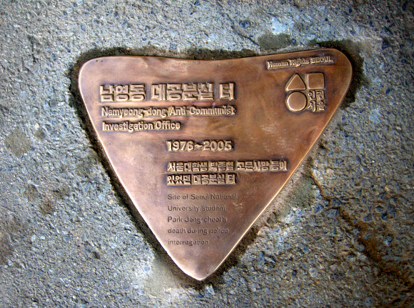 서울시는 1987년 6월 항쟁의 도화선이 된 박종철 열사의 31주기(1월 14일)를 맞아 용산구 남영동 대공분실이 있었던 건물의 출입구 바닥에 국가 폭력에 대한 저항을 상징하는 역삼각형 형태의 동판을 설치했다고 11일 전했다. 남영동 대공분실은 박종철 열사와 ’민주화 운동의 거목’으로 불리는 고(故) 김근태 전 민주통합당 상임고문 등 수많은 민주화 인사들이 끌려와 강도 높은 고문을 당한 곳이다.  서울시 제공=연합뉴스