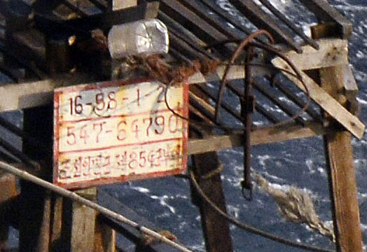 지난달 일본 훗카이도의 무인도 주변에서 발견된 북한 목선에 걸린 금속판에 ‘북한인민군 제854군부대’라고 적혀있는 모습.교도 연합뉴스 