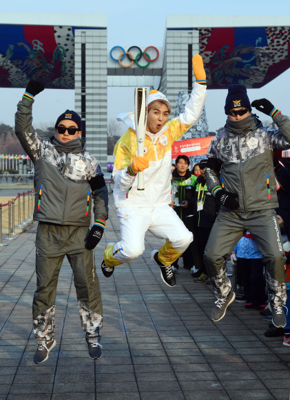 14일 서울 올림픽공원에서 가수 송민호씨가 성화를 들고 점프를 하고 있다.  정연호 기자 tpgod@seoul.co.kr