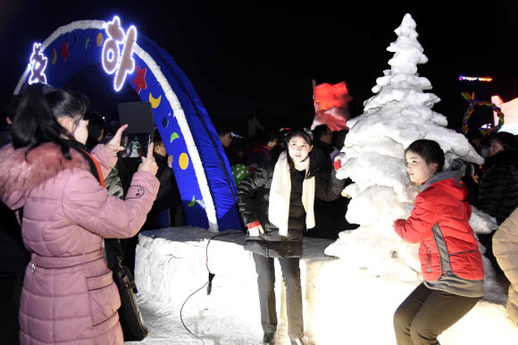 지난달 31일 밤 북한 평양 김일성광장에서 열린 얼음조각 축전에서 시민들이 기념촬영하고 있다.  연합뉴스