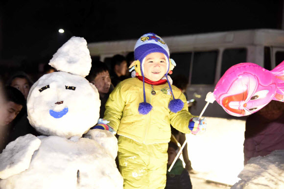 지난달 31일 밤 북한 평양 김일성광장에서 열린 얼음조각 축전에서 한 어린이가 환하게 웃고 있다. 연합뉴스