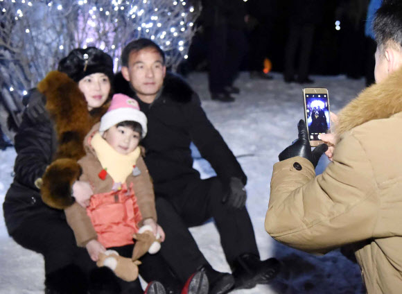 지난달 31일 밤 북한 평양 시민들이 김일성광장에서 열린 얼음조각 축전에서 기념촬영하고 있다.  연합뉴스
