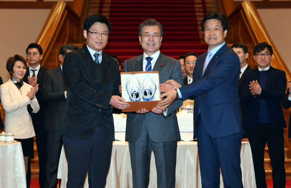 문재인 대통령이 16일 오후 청와대 본관 로비에서 중소·벤처기업 및 소상공인과의 대화에 앞서 재기한 강정완 (주) 공사박사 대표(왼쪽)에게 운동화를 선물한뒤 기념촬영하고 있다.오른쪽은 문창섭 삼덕통상 대표.2018. 01. 16 안주영 기자 jya@seoul.co.kr