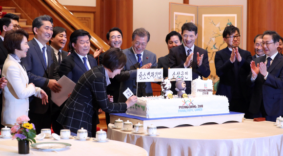 문재인 대통령이 16일 오후 청와대에서 열린 중소 벤처기업 및 소상공인과의 대화에 앞서 참석자들과 함께한 ’’2018년 중소 벤처기업 및 소상공인, 평창 동계올림픽 성공기원’’ 퍼포먼스에서 한무경 여성경제인협회장이 케이크에 ’’사람중심’’이라고 쓴 깃발을 꽂는걸 보며 박수치고 있다. 2018. 01. 16 안주영 기자 jya@seoul.co.kr