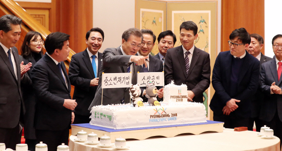 문재인 대통령이 16일 오후 청와대에서 열린 중소.벤처기업 및 소상공인과의 대화에 앞서 동네 빵집을 협동조합화하여 경쟁력을 강화한 인천 패밀리베이커리에서 제작한 ’’2018년 중소벤처기업 및 소상공인, 평창 동계올림픽 성공기원’’ 케이크를 바라보고 있다. 왼쪽은 박성택 중소기업중앙회 회장. 오른쪽은 안건준 벤처협회장.2018. 01. 16 안주영 기자 jya@seoul.co.kr