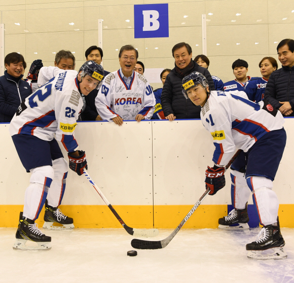 문재인 대통령이 17일 충북 진천 국가대표 선수촌을 방문해 남녀 아이스하키 선수들을 격려하고 페이스 오프를 의미하는 퍽을 던지고 있다.  2018.01.17. 청와대사진기자단