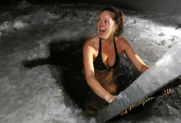 19일(현지시간) 러시아 공현대축일(Epiphany holiday)을 맞아 한 여성이 비키니 차림으로 예니세이강 얼음물에 들어가고 있다. 로이터 연합뉴스