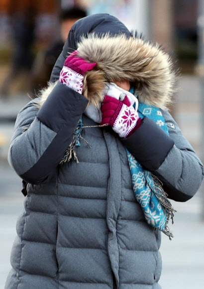 눈이 그치고 한파가 몰아친 23일 오전 서울 종로구 광화문 광장에서 두꺼운 옷으로 중무장한 시민들이 출근길을 서두르고 있다.  연합뉴스