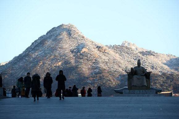 밤사이 한파가 시작된 23일 오전 서울 광화문에서 바라본 북악산에는 하얀 눈이 내려 아침 햇살을 받고 있다.  연합뉴스