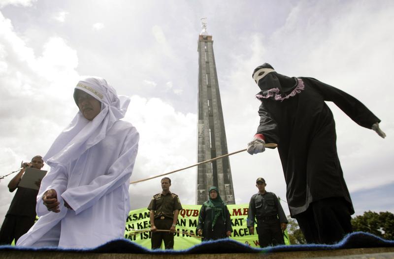 지난 2010년 인도네시아 아체주 아체 베사르에서 미혼 남녀의 접촉을 엄격히 금지한 ‘칼르와 조항’을 어긴 한 여성이 모스크 아래 공개석상에서 이슬람 율법에 따라 공개 매질을 받고 있다.  [로이터 자로사진]
