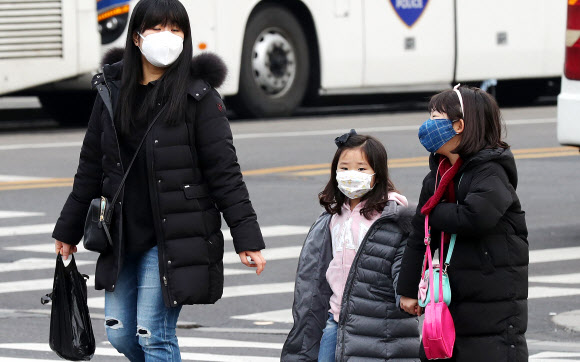미세먼지가 기승을 부린 지난 20일 서울 광화문 인근에서 한 가족이 마스크를 착용하고 걷고 있다.  연합뉴스