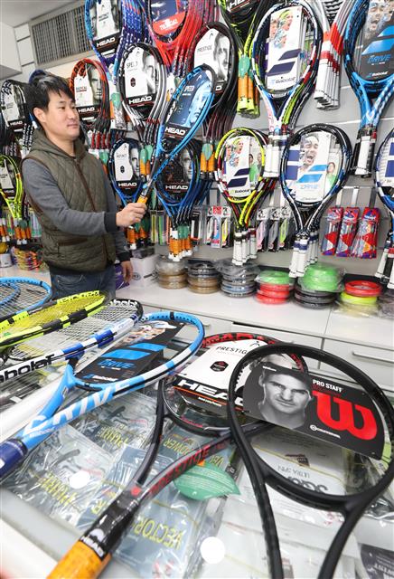 한국 테니스의 간판 정현과 로저 페더러의 호주오픈 4강전이 열린 26일 서울 중구의 한 테니스 용품점에서 직원이 라켓을 정리하고 있다. 업계에 따르면 정현이 남자프로테니스(ATP) 메이저대회인 호주오픈에서 맹활약하면서 라켓과 테니스화 등 관련용품의 판매량이 크게 늘었다. 뉴스1