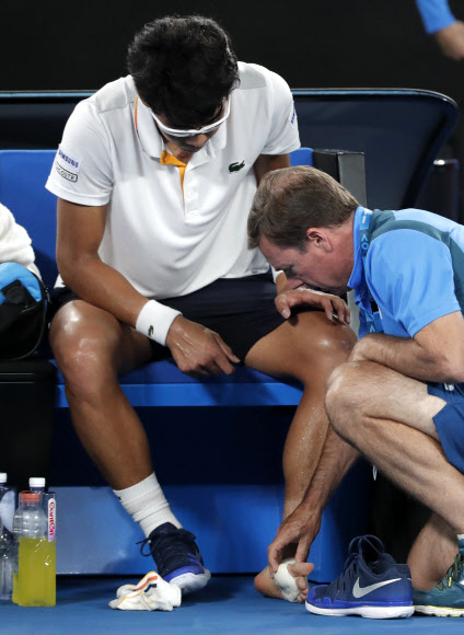26일 호주오픈 4강전에 출전한 정현의 발바닥 부상을 대회 의료진이 만져보고 있다.AP연합뉴스