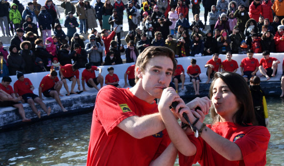 지난 27일 강원 화천군 화천읍 화천천에서 열린 산천어축제 맨손잡기체험에 참가한 외국인이 산천어를 잡고 포즈를 취하고 있다.  화천군 제공=연합뉴스