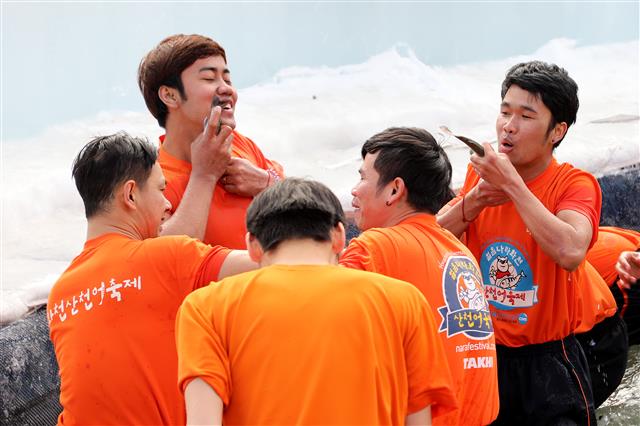 2018 화천산천어 축제 폐막일인 28일 메인이벤트로 자리 잡은 산천어 맨손잡기 행사에 참가한 관광객들이 잡은 산천어를 품속에 넣고 있다.  뉴스1