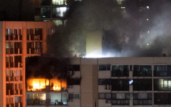 옥상으로 진입한 소방대원들  28일 저녁 서울 은평구 불광동의 한 아파트 상층부에서 화재가 발생해 연기와 함께 불길이 치솟자 소방대원들이 옥상으로 진입해 불을 끄고 있다. 이 화재로 1명이 숨지고 2명이 크게 다쳤다.<br>연합뉴스