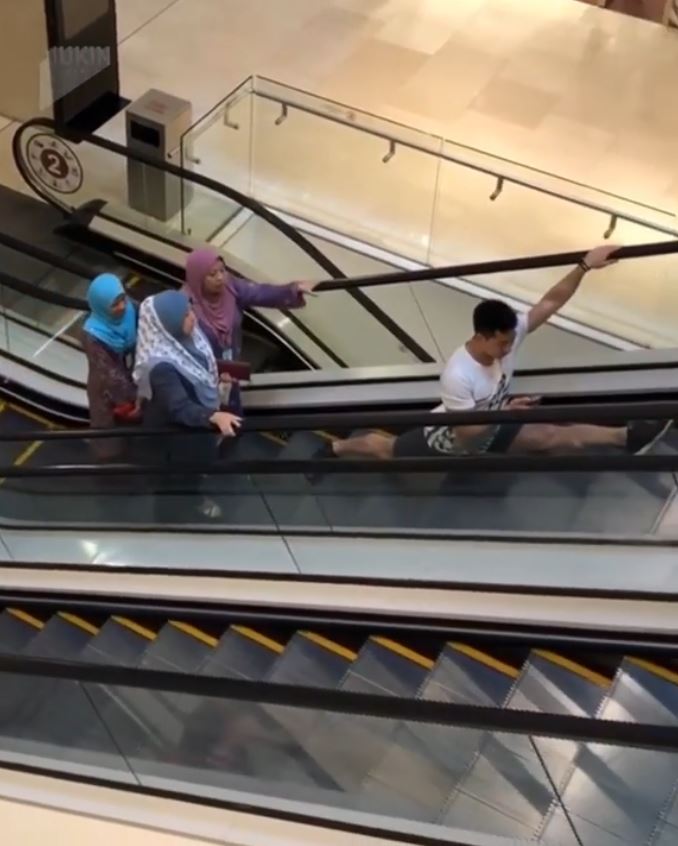 다리 찢기 동작으로 에스컬레이터를 타는 남성(유튜브 영상 캡처)