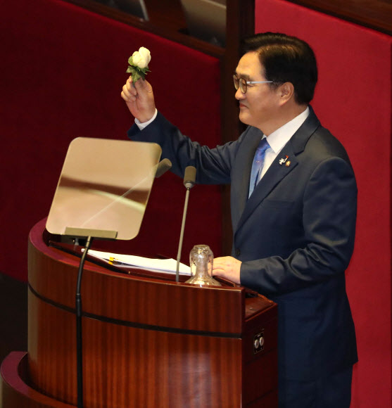 더불어민주당 우원식 원내대표가 31일 국회 본회의에서 교섭단체 대표연설에 앞서 서지현 검사의 성추행 고발을 지지한다며 하얀 장미를 들어 보이고 있다.  연합뉴스