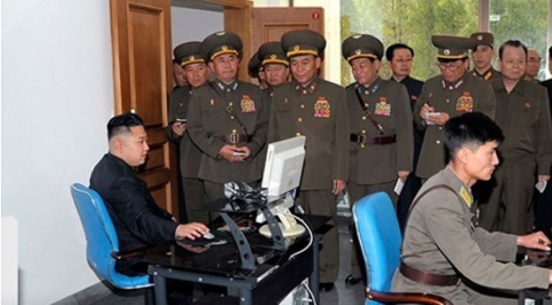 북한 김정은 노동당 위원장이 군인들이 지켜보는 가운데 컴퓨터를 작동하고 있다.