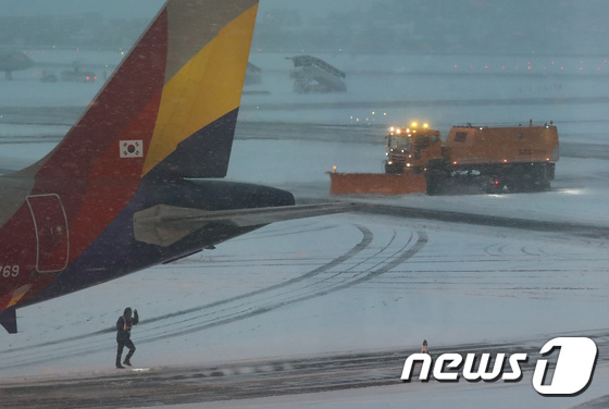 제주지역에 많은 눈이 내린 5일 오전 제주시 제주국제공항 활주로에서 공항 관계자들이 제설작업을 하고 있다. 뉴스1