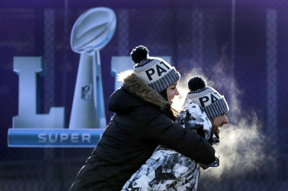 연인으로 보이는 한 쌍의 남녀가 5일 혹한 속에 입김을 내뿜으며 제52회 슈퍼볼이 열리는 US뱅크 스타디움으로 발길을 재촉하고 있다. AP 연합뉴스
