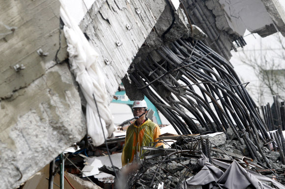 8일(현지시간) 대만 동부 화롄을 강타한 지진으로 기울어진 빌딩에서 구조대가 실종자 수색작업을 하고 있다. AP 연합뉴스