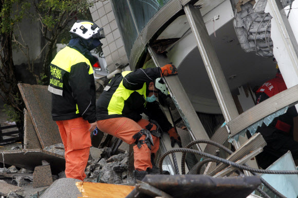 8일(현지시간) 대만 동부 화롄을 강타한 지진으로 기울어진 빌딩에서 구조대가 실종자 수색작업을 하고 있다. AP 연합뉴스