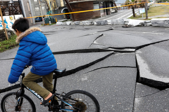 8일 대만 화롄시에서 자전거를 탄 어린이가 규모 6.0의 강진으로 인해 갈라진 도로 위를 지나가고 있다. 지난 6일 밤 발생한 이 지진으로 이날 오후까지 10명이 사망하고 272명이 부상한 것으로 집계됐다. 화롄 로이터 연합뉴스
