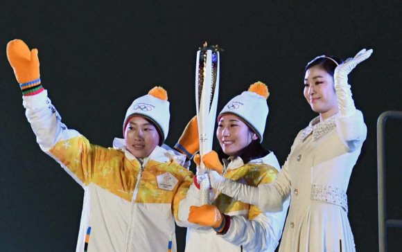 김연아(오른쪽)가 지난 2월 9일 평창동계올림픽 개회식에서 성화 최종주자로 나와 다른 주자들과 성화를 맞잡고 있다. 박지환 기자popocar@seoul.co.kr