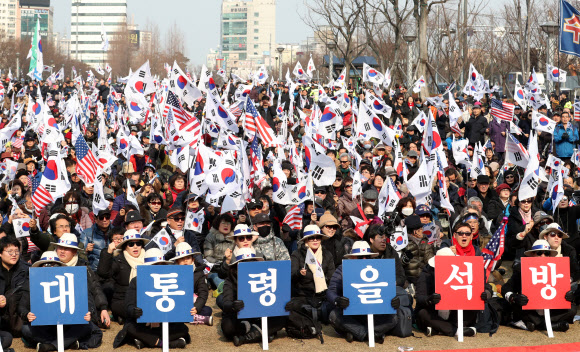 10일 오후 부산 부산진구 송상현광장에서 대한애국당과 박근혜 전 대통령 무죄석방 1천만 서명운동본부 주최로 열린 태극기 집회에서 참가자들이 태극기와 성조기를 흔들고 있다.  연합뉴스