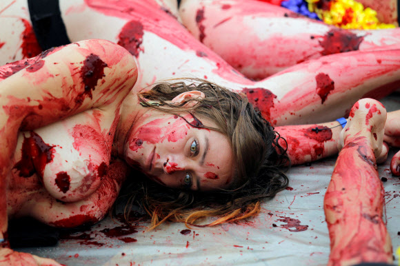 11일(현지시간) 콜롬비아 메델린에서 동물 인권 운동가들이 투우 경기 폐지를 주장하며 온 몸에 가짜 피를 뿌린채 반라로 퍼포먼스 시위를 벌이고 있다. 로이터 연합뉴스