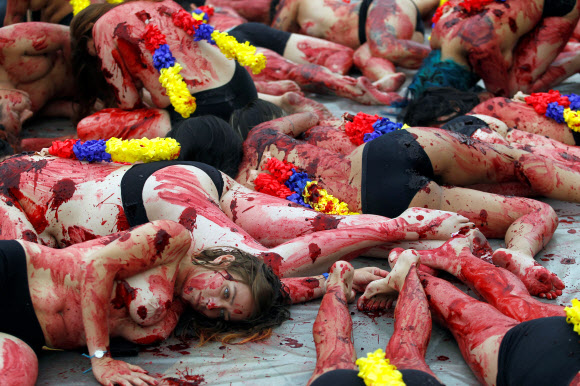 11일(현지시간) 콜롬비아 메델린에서 동물 인권 운동가들이 투우 경기 폐지를 주장하며 온 몸에 가짜 피를 뿌린채 반라로 퍼포먼스 시위를 벌이고 있다. 로이터 연합뉴스