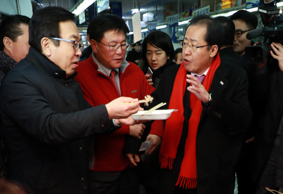 서병수 부산시장이 12일 오후 부산 중구 자갈치 시장에서 자유한국당 홍준표 대표에게 해산물을 권하고 있다.  연합뉴스