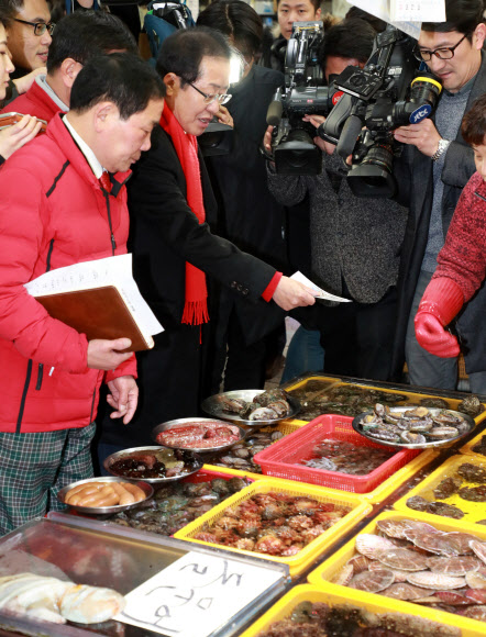 자유한국당 홍준표 대표가 12일 오후 부산 중구 자갈치 시장을 찾아 수산물을 구입하고 있다.  연합뉴스