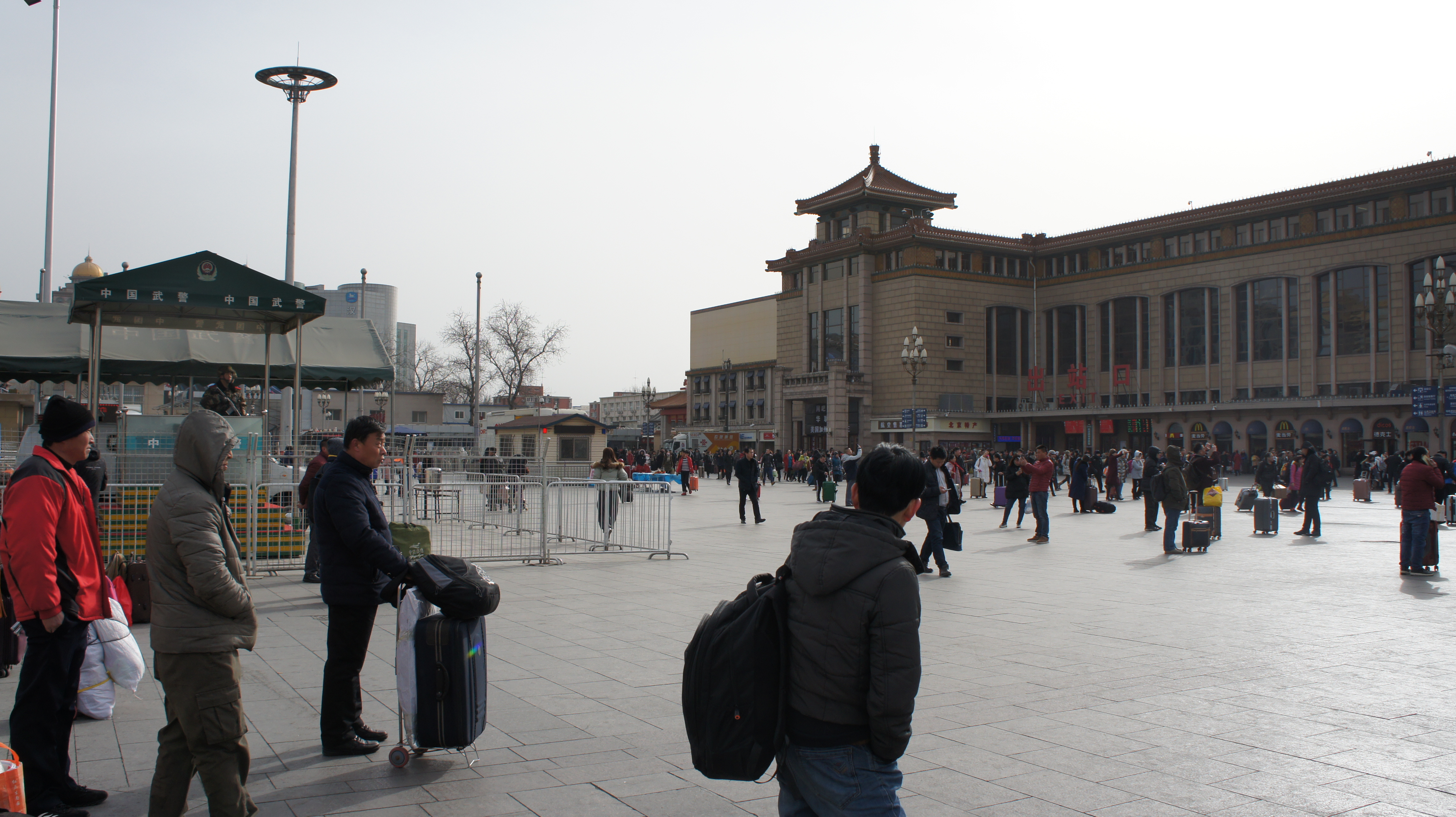 무장군인이 지켜보는 가운데 중국인들이 베이징 기차역에서 귀성길에 오르고 있다.