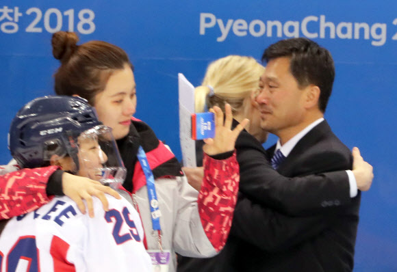 20일 강원도 강릉시 관동하키센터에서 열린 2018 평창동계올림픽 여자 아이스하키 7∼8위 순위 결정전 스웨덴과 경기에서 패한 단일팀 새러 머리 총감독과 북한 박철호 감독이 포옹하며 아쉬움을 표현하고 있다. 2북한 김향미(26번)는 자원봉사자와 기념촬영하고 있다.   연합뉴스