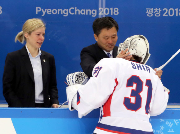 20일 강원도 강릉시 관동하키센터에서 열린 2018 평창동계올림픽 여자 아이스하키 7∼8위 순위 결정전 스웨덴과 경기에서 패한 단일팀 박철호 북한 감독이 골리(골키퍼) 신소정과 아쉬워하며 포옹하고 있다. 왼쪽에서 새러 머리 총감독이 눈시울을 붉은 채 지켜보고 있다.  연합뉴스