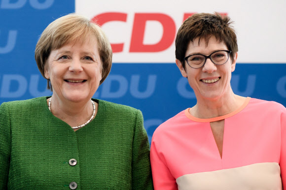 앙겔라 메르켈(왼쪽) 독일 총리가 19일(현지시간) 독일 베를린 기독민주당 당사에서 자신의 최측근이자 ‘미니 메르켈’로 불리는 안네그레트 크람프카렌바우어 자를란트 주총리를 기민당 사무총장으로 지목하고 함께 웃고 있다. 베를린 EPA 연합뉴스