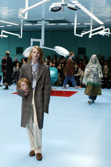 21일(현지시간) 이탈리아 밀라노에서 열린 ‘밀라노 패션위크’ 중 명품 브랜드 ‘구찌(Gucci)’의 가을/겨울 패션쇼에서 모델들이 가짜 사람 머리 모형을 들고 워킹을 하고 있다.<br>AP 연합뉴스