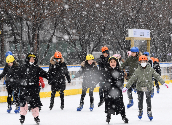 서울 중구 서울시청 앞 서울광장 스케이트장을 찾은 시민들이 눈을 맞으며 스케이트를 타고 있다. 손형준 기자 boltagoo@seoul.co.kr