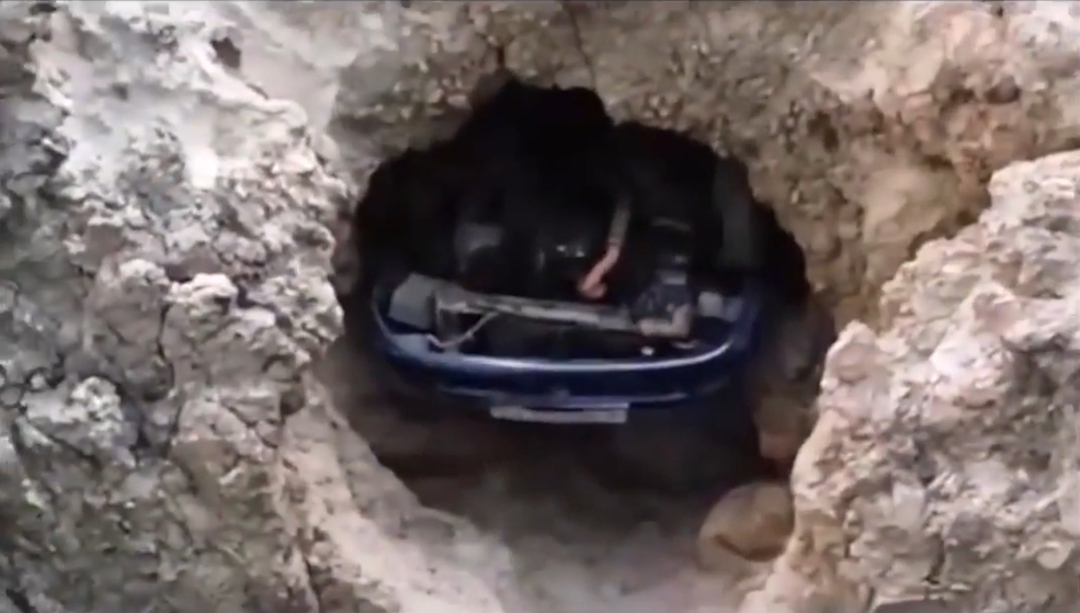 거대한 암벽 구멍에 빠져 있는 의문의 차량(유튜브 영상 캡처)
