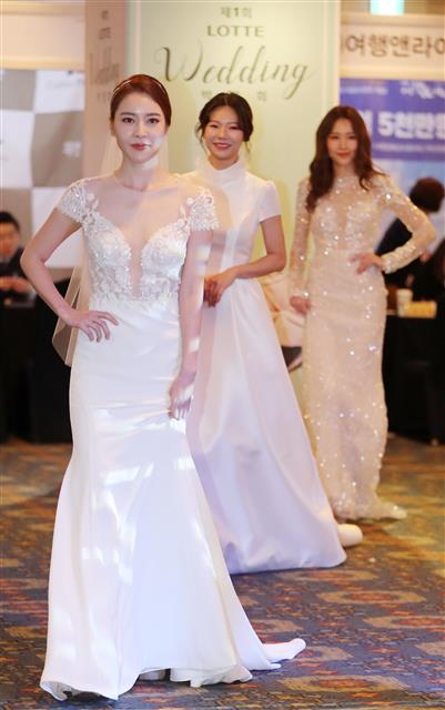 모델들이 1일 오전 서울 중구 소공동 롯데호텔에서 열린 ’제1회 롯데웨딩 박람회’에서 웨딩드레스를 선보이고 있다.  롯데백화점은 오는 2일까지 이번 행사를 통해 봄에 결혼식을 올리는 예비 신혼부부에게 웨딩드레스와 턱시도 트렌드를 소개한다.  뉴스1
