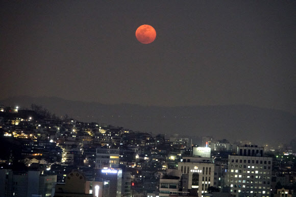 무술년 대보름인 2일 서울시 아차산 위로 붉은 대보름달이 떠오르고 있다. 서울 동쪽의 야경과 붉은색의 대보름달이 아름답게 보인다. 대보름달이 붉게 보이는 것은 지표면에서 가까워서 빛의 파장이 길고 서쪽 하늘로 지는 태양 빛의 영향이다. 달의 붉은빛은 지표면에서 멀어지면서 빛의 파장이 짧아져 하얀색으로 보이게 된다.  연합뉴스
