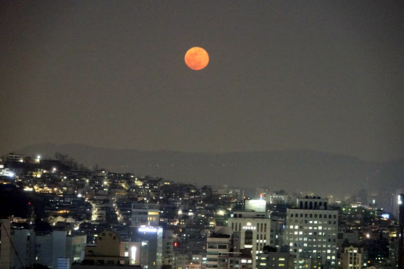 무술년 대보름인 2일 서울시 아차산 위로 붉은 대보름달이 떠오르고 있다. 서울 동쪽의 야경과 붉은색의 대보름달이 아름답게 보인다. 대보름달이 붉게 보이는 것은 지표면에서 가까워서 빛의 파장이 길고 서쪽 하늘로 지는 태양 빛의 영향이다. 달의 붉은빛은 지표면에서 멀어지면서 빛의 파장이 짧아져 하얀색으로 보이게 된다.  연합뉴스