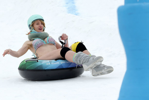 4일(현지시간) 루마니아 시비우의 한 스키 리조트에서 열린 ‘비키니 레이스 컨테스트’에서 참가자가 튜브를 타고 내려오고 있다. 비키니 레이스는 수영복과 몇몇 겨울 용품만 착용한 여성들이 참가 가능하다. EPA 연합뉴스