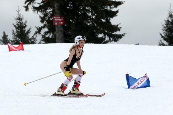 4일(현지시간) 루마니아 시비우의 한 스키 리조트에서 열린 ‘비키니 레이스 컨테스트’에서 참가자가 스키를 타고 내려오고 있다. 비키니 레이스는 수영복과 몇몇 겨울 용품만 착용한 여성들이 참가 가능하다. EPA 연합뉴스