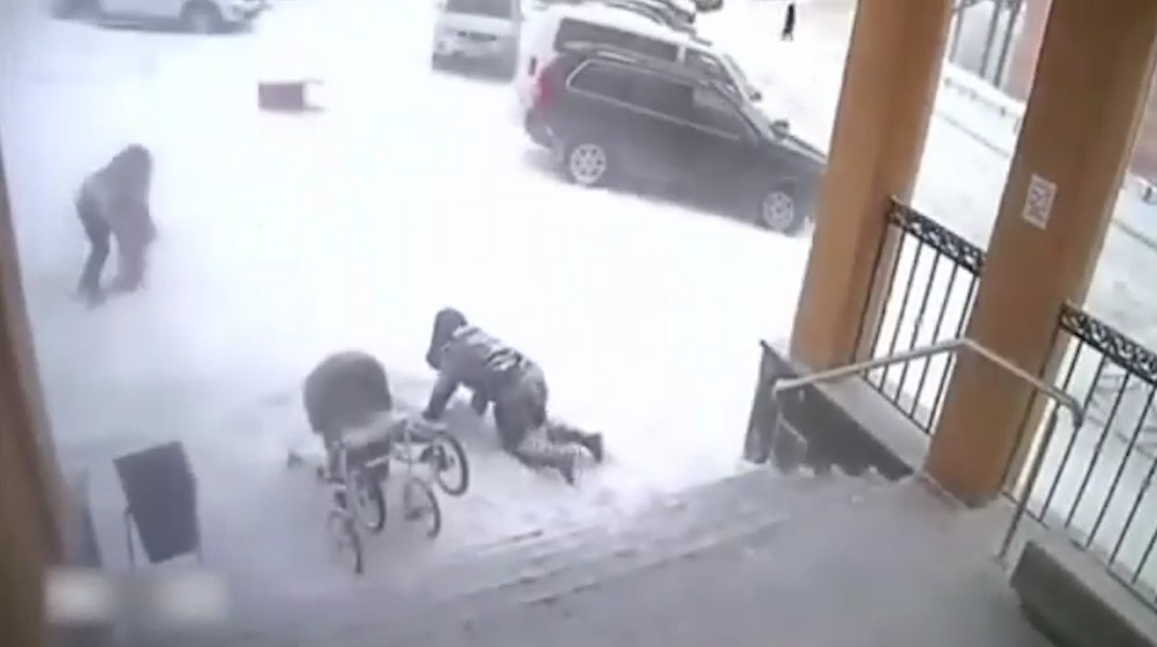 러시아 어느 지역의 건물 위에서 떨어진 ‘눈사태’가 입구 앞에 있던 두 여성과 한 아이를 덮치는 순간 모습(유튜브 영상 캡처)