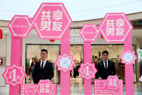 중국 산둥 성 빈저우에서 열리는 국제 여성의 날 쇼핑 센터에서 부스 뒤에 서 있는 남성의 모습을 촬영해 1위안에 ‘공유 남자친구’를 빌릴 수 있다. 2018.03.08  연합뉴스