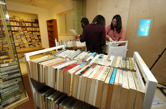 12일 오전 서울도서관에서 관계자들이 성추행 논란에 휩싸인 시인 고은의 작품세계를 조명한 ’만인의 방’ 을 철거하고 있다.  연합뉴스