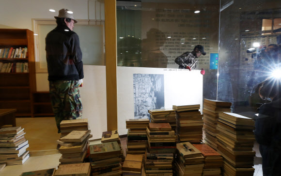 12일 오전 서울도서관에서 관계자들이 성추행 논란에 휩싸인 시인 고은의 작품세계를 조명한 ’만인의 방’을 철거하고 있다.  연합뉴스